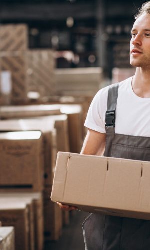 Young man working at a warehouse with boxes